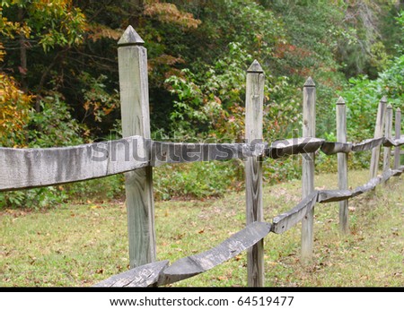 An old wooden fence along a ditch bank in the woods with room for your text using selective focus set to the front of the fence