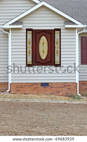 A Beautiful wood framed etched glass window in a vinyl sided house on a brick foundation along with gutters on both sides with room for your text.