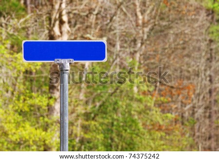 A road sign against the woods  using selective focus and a shallow depth of field with room for your text.