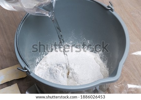 Mixing white plaster in a bucket with a stirrer. Close-up. Foto stock © 