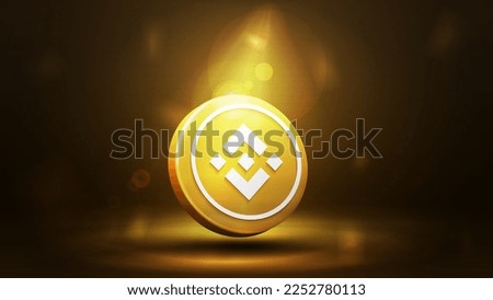 Gold binance 3d coin icon on a dark gold blurred background.