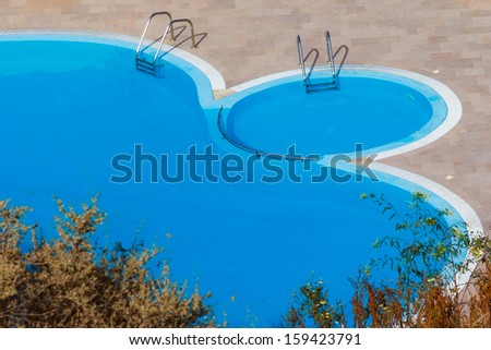 Small round swimming pool in hotel\'s yard filled with water