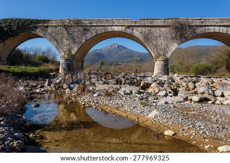 Old vintage stone bridge over Karnionas (or Xerilas) river near Leontari village in Arcadia, Greece.  The bridge was built in 1890 and it is used until today