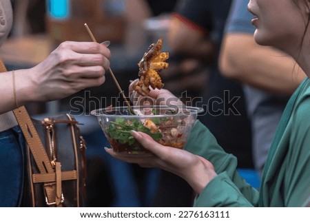 Similar – Image, Stock Photo Woman eating grilled squid skewer in restaurant