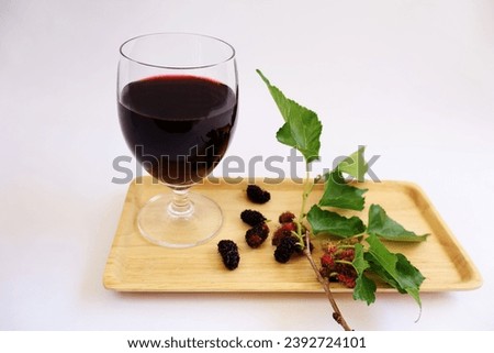 Ready-to-drink mulberry juice with dark purple ripe berries and light red ripe ones and green leafy branches placed in a wooden tray. It is a fruit that is high in vitamin C. on a white background Stok fotoğraf © 