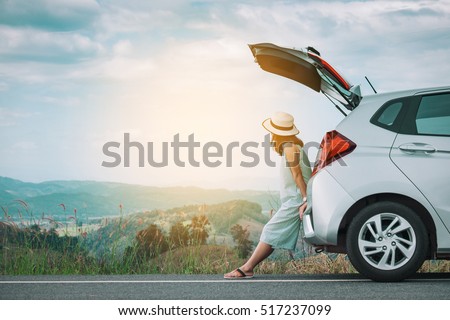 Woman traveler sitting on hatchback car with mountain background in vintage tone Foto stock © 