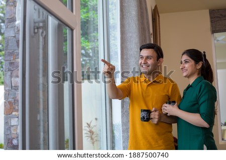 Couple drinking coffee and admiring view from balcony 