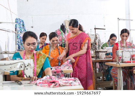 Woman textile worker checking garment stock at factory