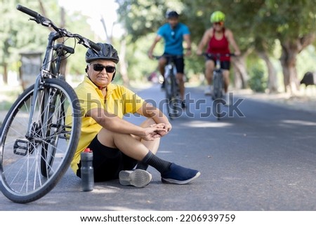 Similar – Foto Bild Mountainbiker aufgestützt auf Fahrradlenker blickt in die Ferne.