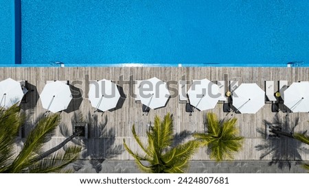Similar – Image, Stock Photo Umbrellas and empty deckchairs collected on the beach shore in summer.