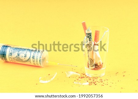 broken cigarettes and a rolled-up dollar in a broken glass and a syringe with a dollar inside. smoking cure Сток-фото © 