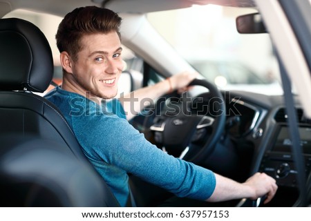 Happy young male driver behind the wheel. The guy in the car. Lifestyle scene in the car dealership Stock foto © 