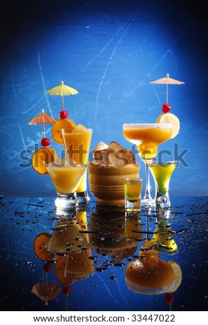 Orange party drinks on blue. Passion Daiquiri; Mango Margarita; Screwdriver and Shooters