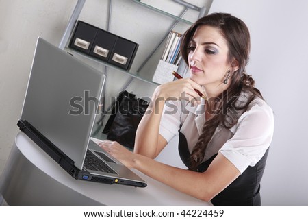 Young brunette examining data at her contemporary office