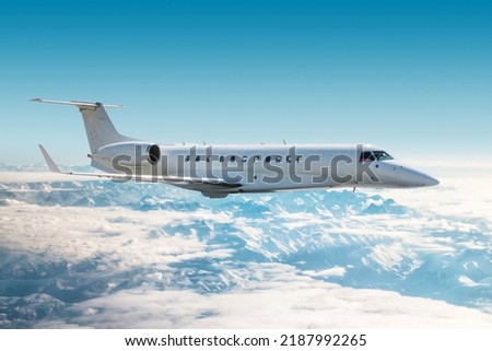White modern private jet flies over snow-covered mountain ranges Foto stock © 