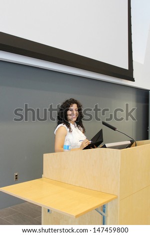 Woman behind a podium, ready for a speech