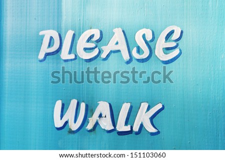 Please walk. A wooden sign that asks people to walk.
