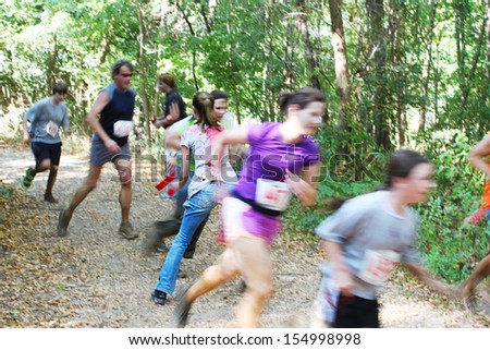 MUSKOGEE, OK - Sept. 14: Runners hurry through zombie-infested forest during the Castle Zombie Run at the Castle of Muskogee in Muskogee, OK on September 14, 2013.