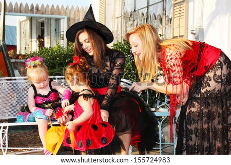 Little girls and their mothers check out candy after trick-or-treating