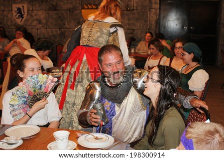 MUSKOGEE, OK - MAY 24: A knight greets female guests during the Queen\'s tea at the Oklahoma 19th annual Renaissance Festival on May 24, 2014 at the Castle of Muskogee in Muskogee, OK.