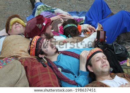 MUSKOGEE, OK - MAY 24: A group of teenagers dressed as traveling gypsies rest near cabins at the Oklahoma 19th annual Renaissance Festival on May 24, 2014 at the Castle of Muskogee in Muskogee, OK.