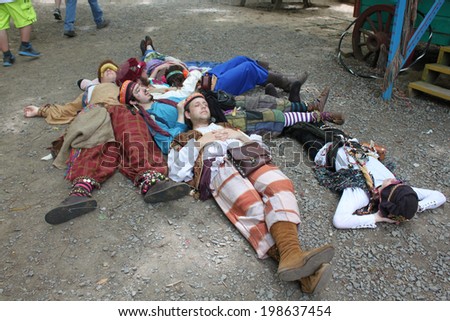 MUSKOGEE, OK - MAY 24: A group of teenagers dressed as traveling gypsies rest near cabins at the Oklahoma 19th annual Renaissance Festival on May 24, 2014 at the Castle of Muskogee in Muskogee, OK.