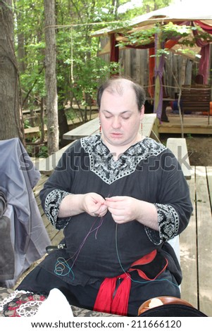 MUSKOGEE, OK - MAY 24: A man shows off craft of lace making at the Oklahoma 19th annual Renaissance Festival on May 24, 2014 at the Castle of Muskogee in Muskogee, OK