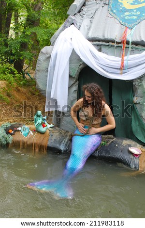 MUSKOGEE, OK - MAY 24: A woman dressed as a fairy mermaid shares treasures and smiles with kids at Oklahoma 19th annual Renaissance Festival on May 24, 2014 at the Castle of Muskogee in Muskogee, OK
