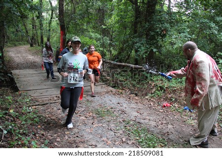 MUSKOGEE, OK - Sept. 13: Athletes run through zombie-infested forest during the Castle Zombie Run at the Castle of Muskogee in Muskogee, OK on September 13, 2014.