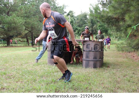MUSKOGEE, OK - Sept. 13: Athletes try to run through obstacles and avoid bloody zombies during the Castle Zombie Run at the Castle of Muskogee in Muskogee, OK on September 13, 2014.