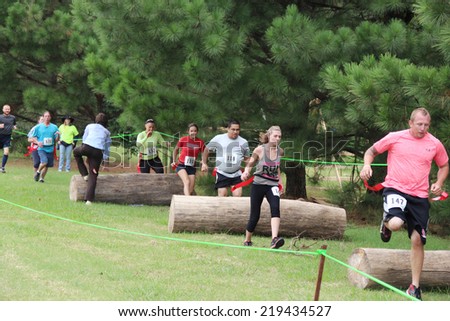 MUSKOGEE, OK - Sept. 13: Athletes jump over obstacles during the Castle Zombie Run at the Castle of Muskogee in Muskogee, OK on September 13, 2014.