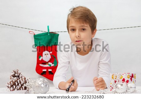 Boy writes a letter to Santa Claus.