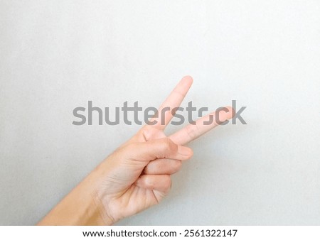 Similar – Image, Stock Photo Female palm with V-sign with rainbow bracelet