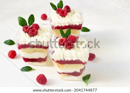 Panna cotta with raspberry , delicious italian dessert with fresh berries., portion dessert in a clear plastic cups. White wooden board, healthy eating , healthy dessert, italian dessert background