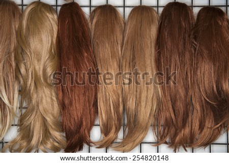 Different colored wigs for women placed side by side