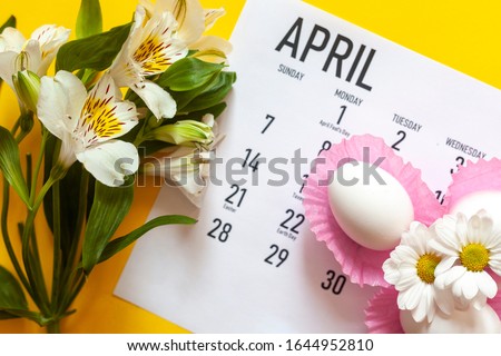 April 2020 calendar, cute pure white easter eggs and white flowers on yellow background. April 2020 monthly calendar. Top view. View from above. Monthly April calendar