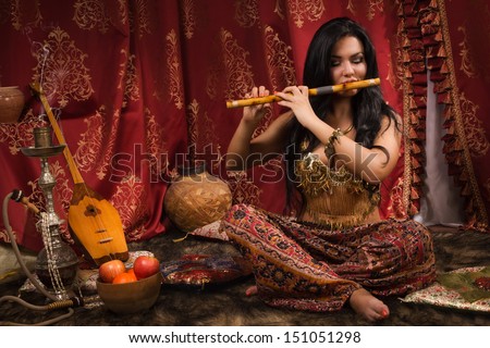 Beautiful oriental woman playing the flute