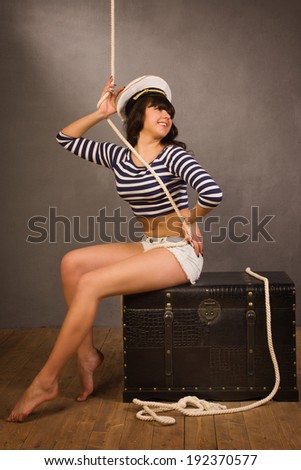 Adorable woman sailor in pinup style wearing sea admirals hat and sexy top