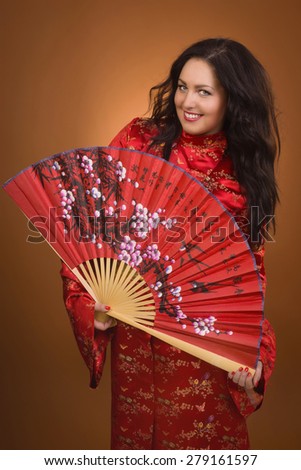 attractive girl in red asian bathrobe with fan