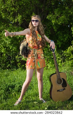 Amazing girl traveling with her guitar. Hippie style.