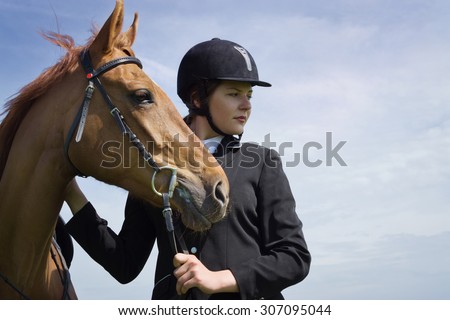 Beautiful young girl jockey with her horse dressing uniform competition