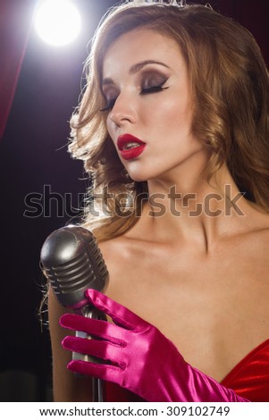 Retro female singer sing holding vintage microphone