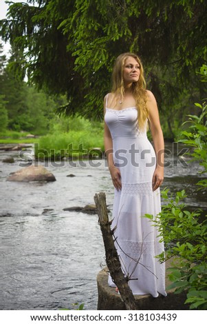 Beautiful woman in a wild forest and forest river