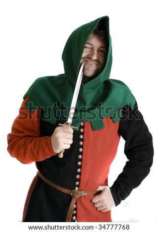 Medieval robber in an ancient red and black suit  checks an edge of a knife