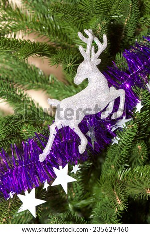 Brilliant deer running along the path of the stars on the Christmas tree