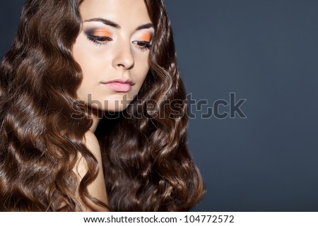Portrait of young beautiful woman with long curly volume hair