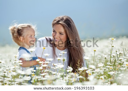 Happy woman and child in the blooming spring garden.Mothers day holiday concept
