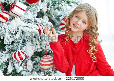 Happy little girl in Christmas at the Christmas tree. Baby New Year holiday