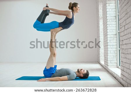 Portrait of a healthy girl and guy doing exercise to relax in the gym. yoga