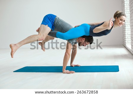 Portrait of a healthy girl and guy doing exercise to relax in the gym. yoga